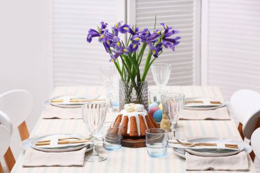 Paskalya pastası ve çiçeklerle dolu bir masa.