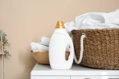 Çamaşır odasında çamaşır makinesinde çamaşır sepeti ve bir şişe deterjan.