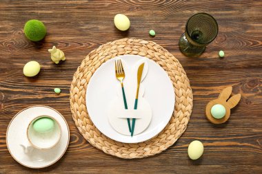 Paskalya yumurtaları ve tahta arka planda oyuncak tavşanla güzel bir masa.