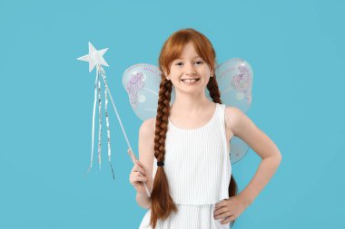 Mavi arka planda asası olan sevimli kızıl saçlı peri.