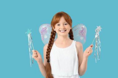 Mavi arka planda asaları olan sevimli kızıl saçlı peri.