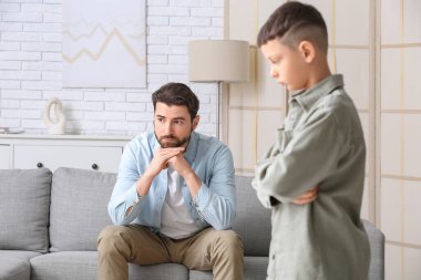 Genç baba ve küçük oğlu evde tartıştıktan sonra düşünüyorlar.