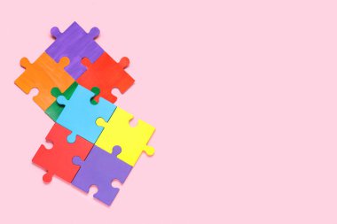 Pembe arka planda farklı renkli yapboz parçaları. Otistik bozukluk kavramı
