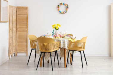 Yemek odasında lale çiçekleri ve Paskalya süslemeleri olan güzel bir masa.