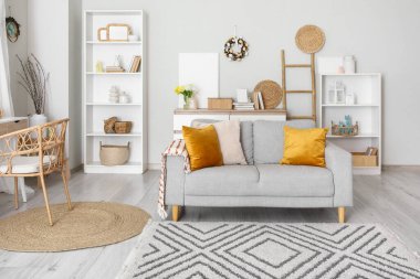 Paskalya için dekore edilmiş oturma odasının içinde kanepe, raf üniteleri ve çelenkler var.