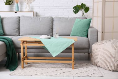 Gri kanepesi ve masası olan oturma odasının içinde.