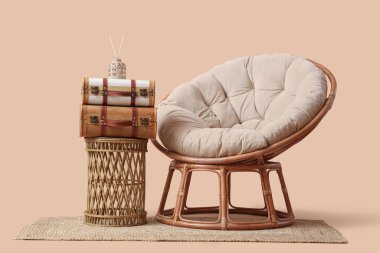 Şık koltuk, sehpa ve bej arka planda klasik bavul.