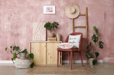 Sandalyesi, ahşap dolabı ve çiçekleri olan şık bir oturma odası.