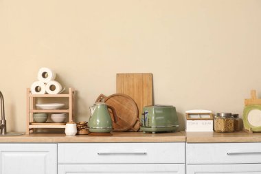 Kurabiyeli elektrikli çaydanlık, mutfakta bir kavanoz şeker ve tost makinesi.