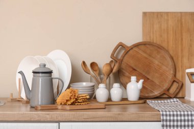 Mutfaktaki masada lezzetli waffle ve çatal bıçaklı çaydanlık.