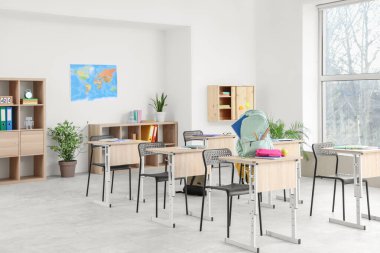 Masaları ve raf üniteleri olan sınıfın içi