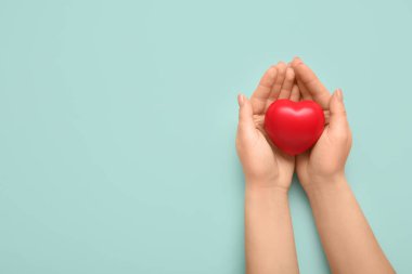 Yeşil arka planda kalbi olan bir kadın eli. Dünya Sağlık Günü