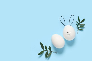 Komik Paskalya yumurtaları ve bitki yapraklarıyla renklendirilmiş kompozisyon