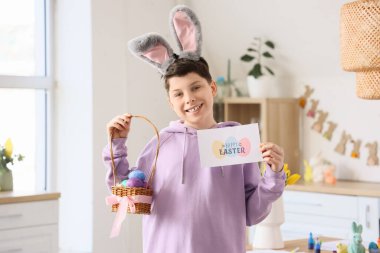 Paskalya yumurtası ve kartı mutfakta olan ergen çocuk.