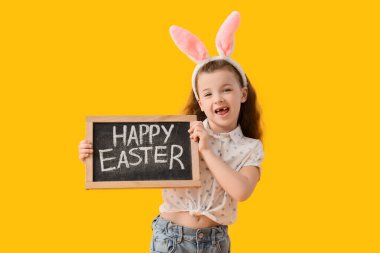 Tavşan kulaklı şirin bir kız. Elinde yazı tahtası var. Sarı arka planda Mutlu Paskalyalar.