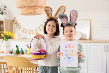 Mutfakta paskalya yumurtası ve kartı olan şirin küçük kızlar.