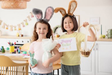 Tavşan kulaklı ve mutfakta paskalya yumurtası olan tatlı küçük kızlar.