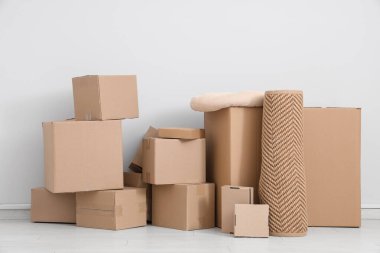 Beyaz duvarın yanında bir sürü farklı paket ve yastık var.