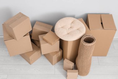 Beyaz duvarın yanında bir sürü farklı paket ve yastık var.