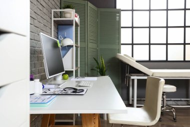 Modern tıp ofisinde bilgisayarlı bir doktorun çalışma yeri.