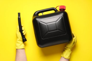 Erkekler sarı arka planda teneke kutu ve lastik başlık tutuyor.