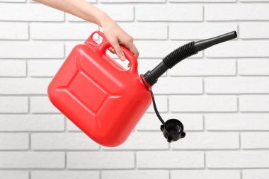 Beyaz tuğlalı arka planda lastik başlıklı kadın el kutusu.