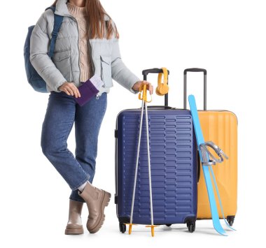 Beyaz arka planda bavulları ve kayakları olan kadın turist.