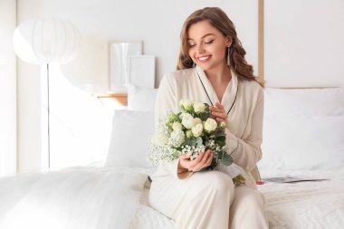 Gelin ve düğün buketi yatak odasında oturuyor.