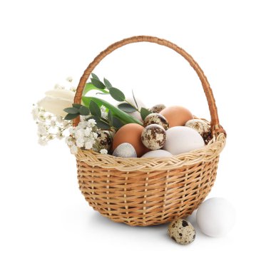 Beyaz arka planda güzel Paskalya yumurtaları ve çiçekli hasır sepet.