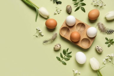 Yumurta tutacağı, Paskalya yumurtası, yeşil yapraklar ve yeşil arka planda tüyleri olan kompozisyon