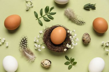 Yuvalı kompozisyon, Paskalya yumurtaları, yeşil arka planda çiçekler ve tüyler, yakın plan
