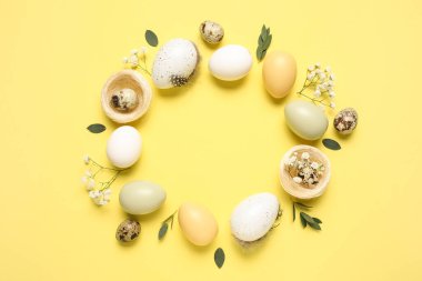 Paskalya yumurtalarından, çiçeklerden ve sarı arkaplanda yapraklardan yapılmış çerçeve