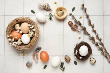 Yuvadan, Paskalya yumurtalarından, çiçeklerden ve beyaz fayanslı arkaplanda söğüt dallarından yapılmış çerçeve