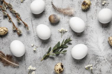 Çiçekli, tüylü ve gri arka planda yapraklı Paskalya yumurtaları