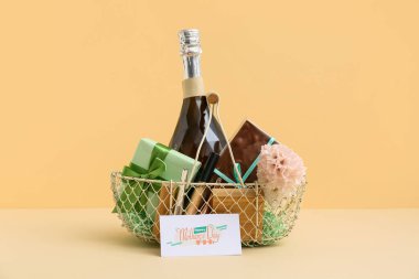 Bej arka planda Anneler Günü için şampanya şişesi, çikolata ve kozmetik ürünleri sepeti.