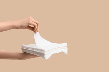 Bej arka planda kağıt peçeteli kadın elleri