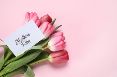 Renkli tebrik kartı olan bir buket güzel pembe lale çiçeği. Anneler Günü kutlaması