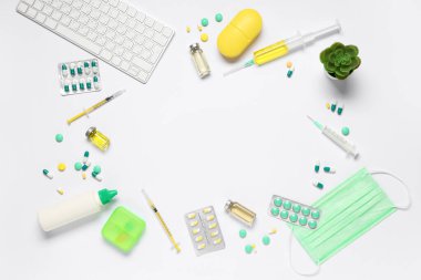 Beyaz arka planda haplar, şırıngalar, ampuller ve klavyeden yapılmış çerçeve. Dünya Sağlık Günü