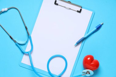 Steteskoplu boş bir pano ve mavi arka planda kırmızı kalp. Dünya Sağlık Günü
