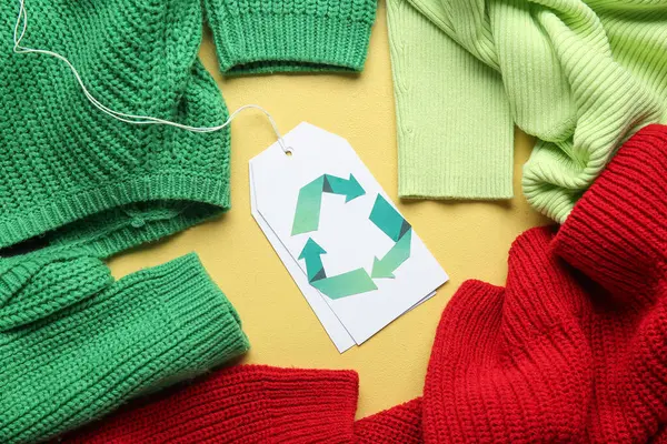 Sarı arkaplanda geri dönüşüm etiketi olan kıyafetler