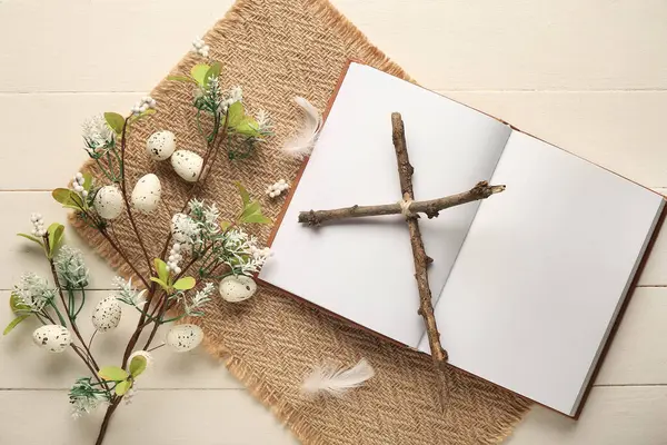 Boş kitaplı haç ve beyaz ahşap arka planda güzel çiçekler. Paskalya kutlaması