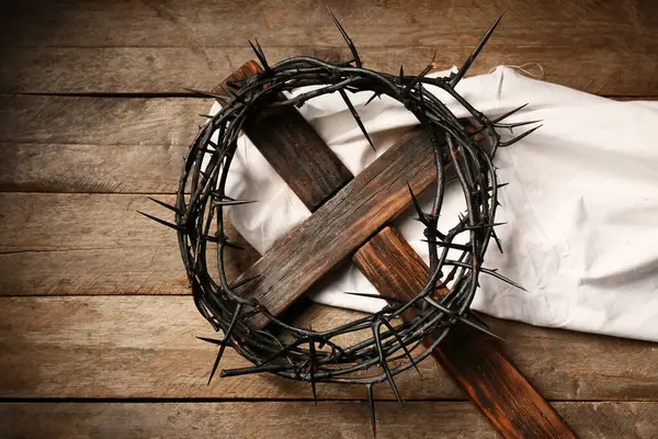 Dikenli taç haç ve ahşap arka planda beyaz bez