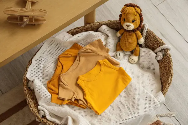 Bebek kıyafetleri ve oyuncak aslanlı sepet.