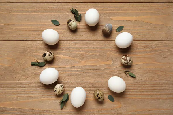 Paskalya yumurtalarından ve ahşap arka plandaki yapraklardan yapılmış.