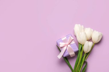 Güzel beyaz lale çiçekleri ve leylak arkaplanlı hediye kutusu. Anneler Günü kutlaması