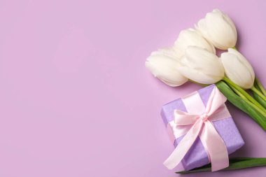 Güzel beyaz lale çiçekleri ve leylak arkaplanlı hediye kutusu. Anneler Günü kutlaması