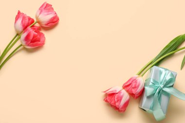 Güzel lale çiçekleri ve sarı arka planda hediye kutusu. Anneler Günü kutlaması