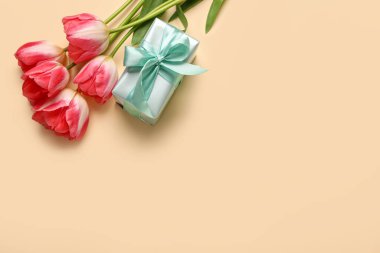 Güzel lale çiçekleri ve sarı arka planda hediye kutusu. Anneler Günü kutlaması