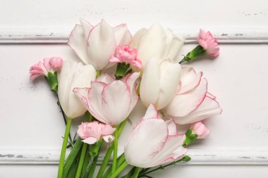 Beyaz arka planda güzel laleler ve karanfil çiçekleri. Anneler Günü kutlaması