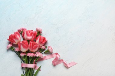 Açık mavi arka planda karanfil çiçekli güzel laleler. Anneler Günü kutlaması